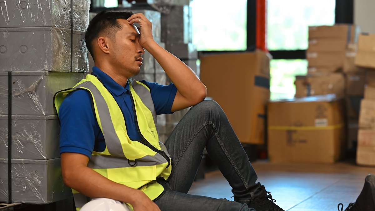 Tired warehouse worker resting during his shift
