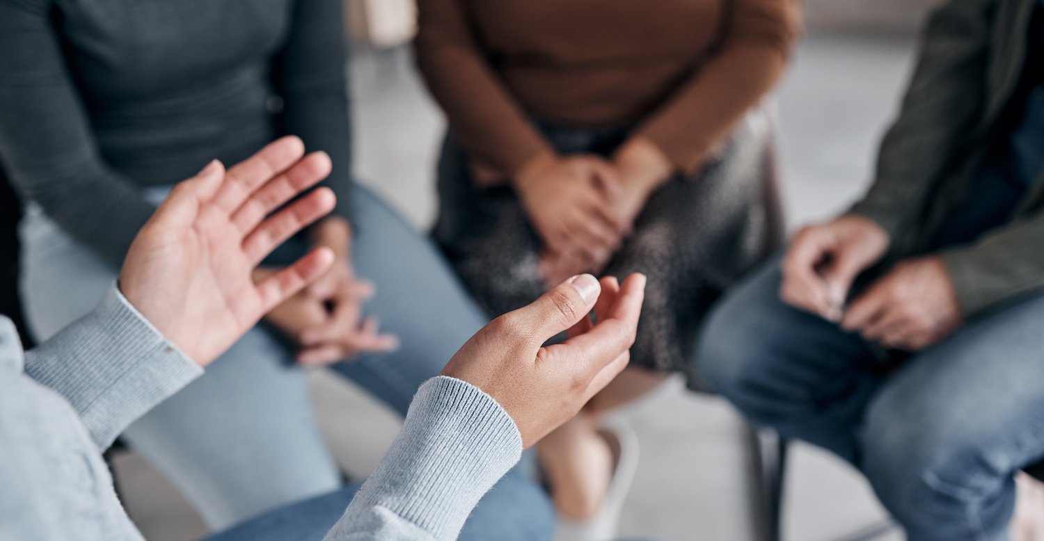 Group therapy session of six people sitting in a circle