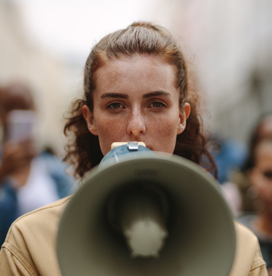 Woman speaking into a megaphone in public as an example of disturbing the peace