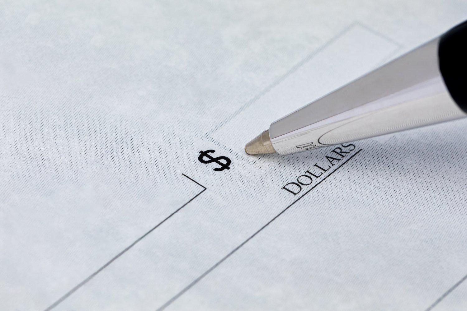 Closeup of a ballpoint pen filling out a check