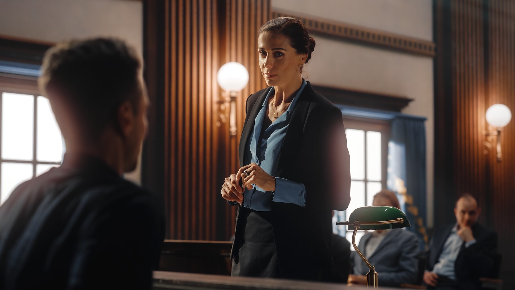 Prosecutor cross-examining a witness during a preliminary hearing in a large courtroom