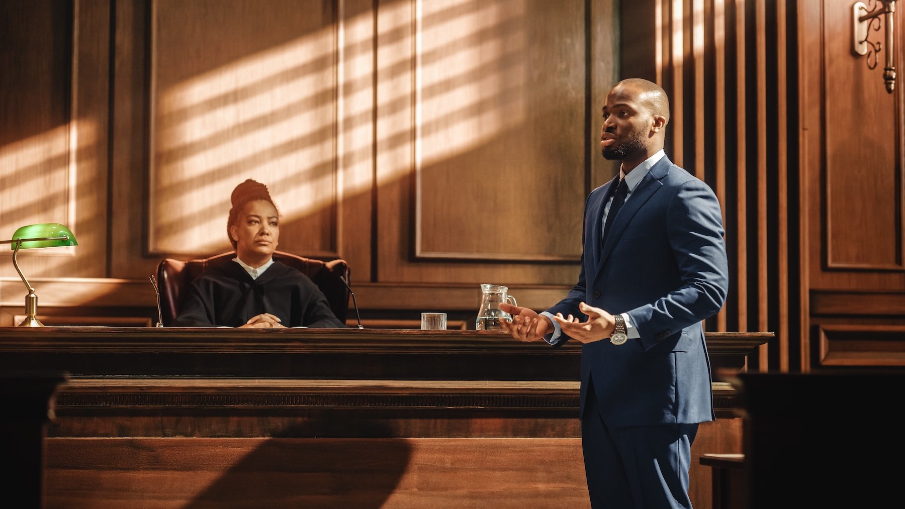 Criminal defense attorney arguing during a preliminary hearing in a wooden courtroom in front of a judge