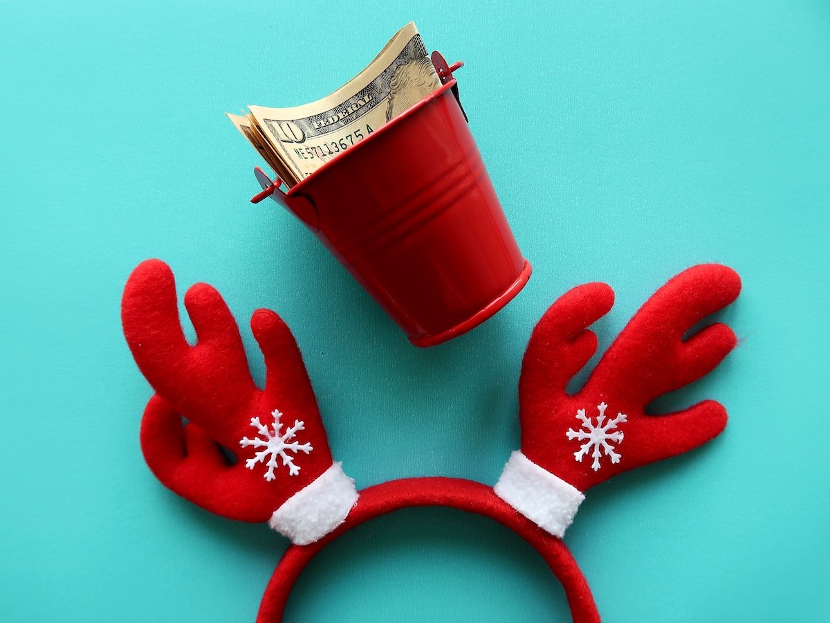 Festive reindeer ears with a cup of cash against a blue background