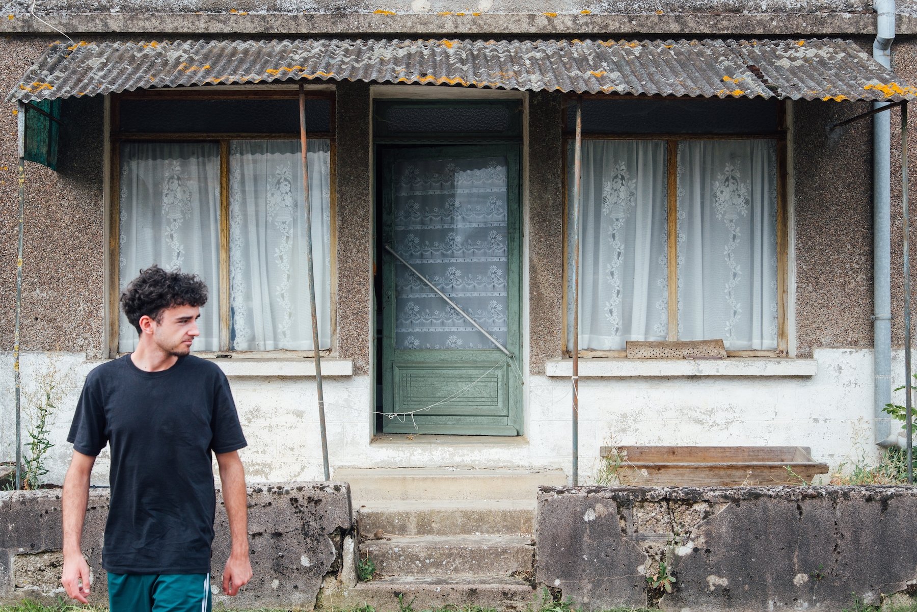 Hombre ocupando ilegalmente una casa en ruinas en un vecindario deteriorado