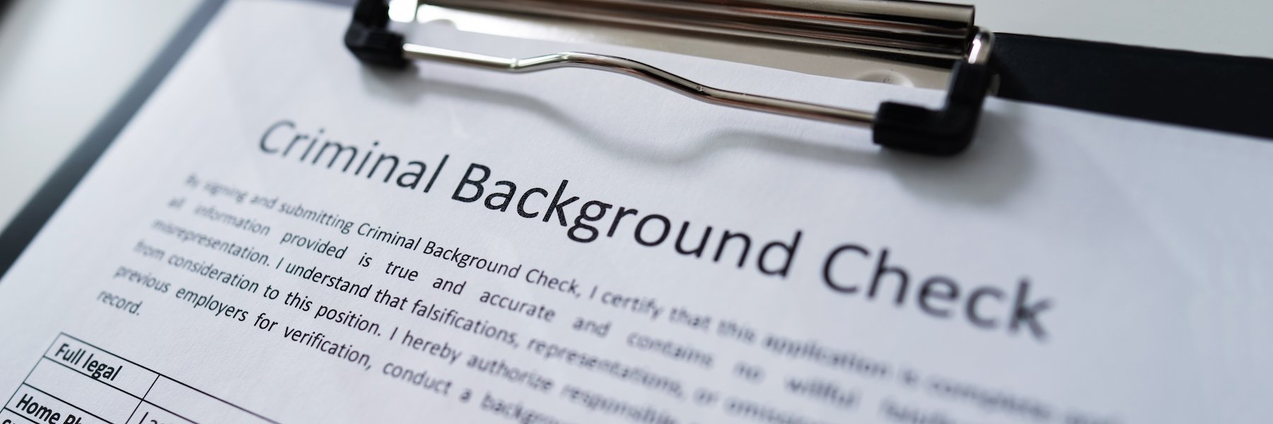 Clipboard with a paper that says "criminal background check"