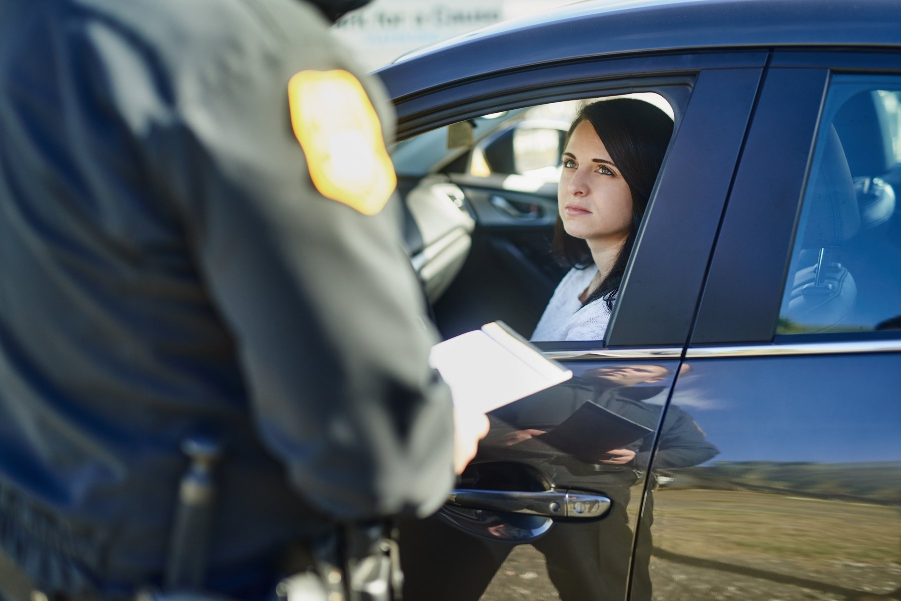 Oficial pidiendo la identificación a la conductora durante una parada de tráfico