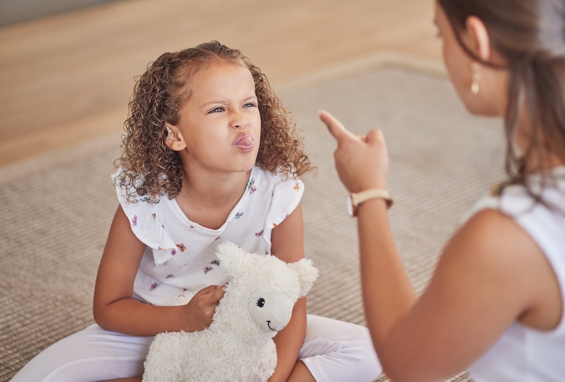 Madre disciplinando a su hija que le saca la lengua