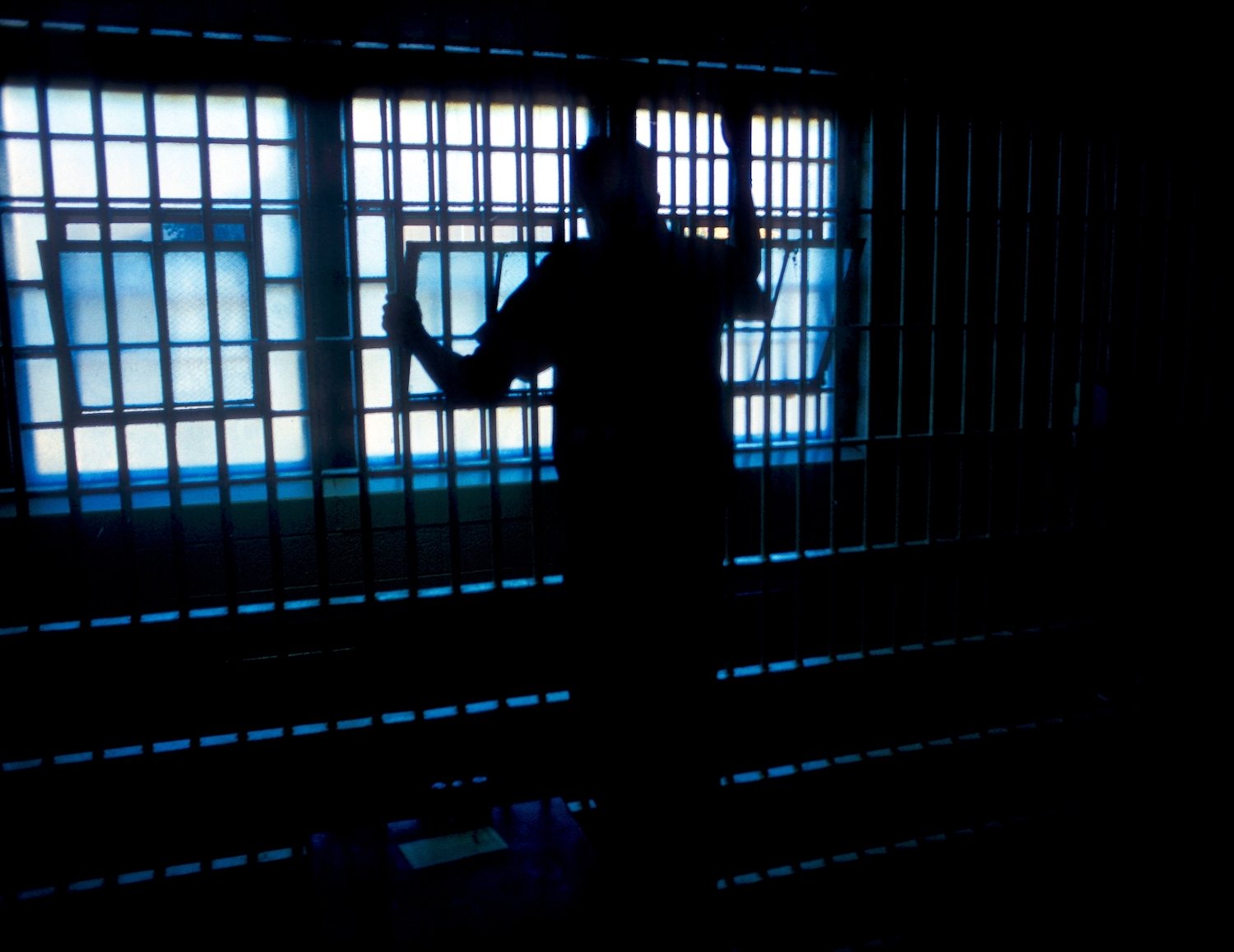 Recluso mirando por la ventana de su celda durante el día