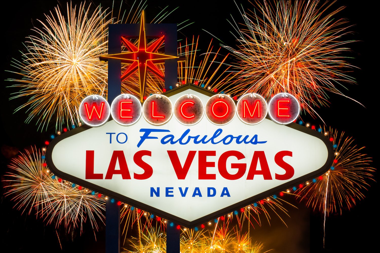 "Welcome with Las Vegas" sign at night against fireworks
