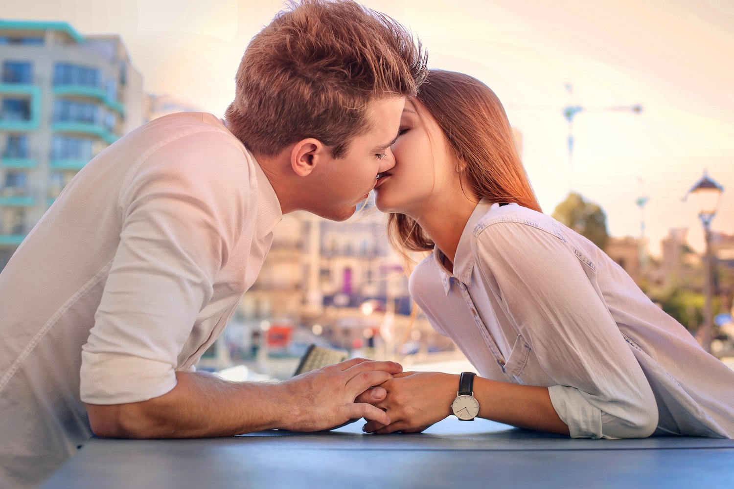 Young couple kissing while outside in the day