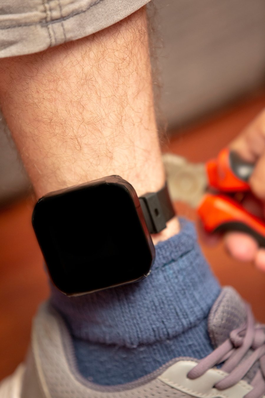 closeup of ankle monitor on a probationer's ankle at home