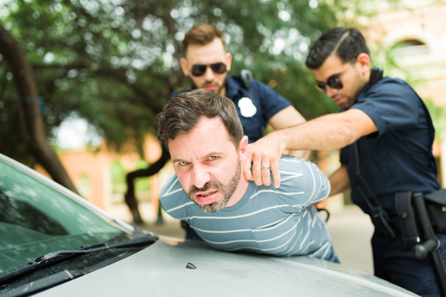 Two police officers arresting a driver following a DUI investigation