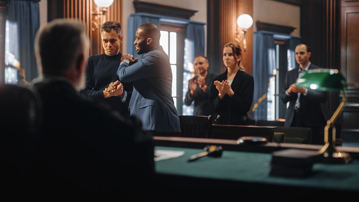 Abogado defensor felicitando a su cliente tras lograr que un caso sea desestimado debido a un estatuto de limitaciones caducado