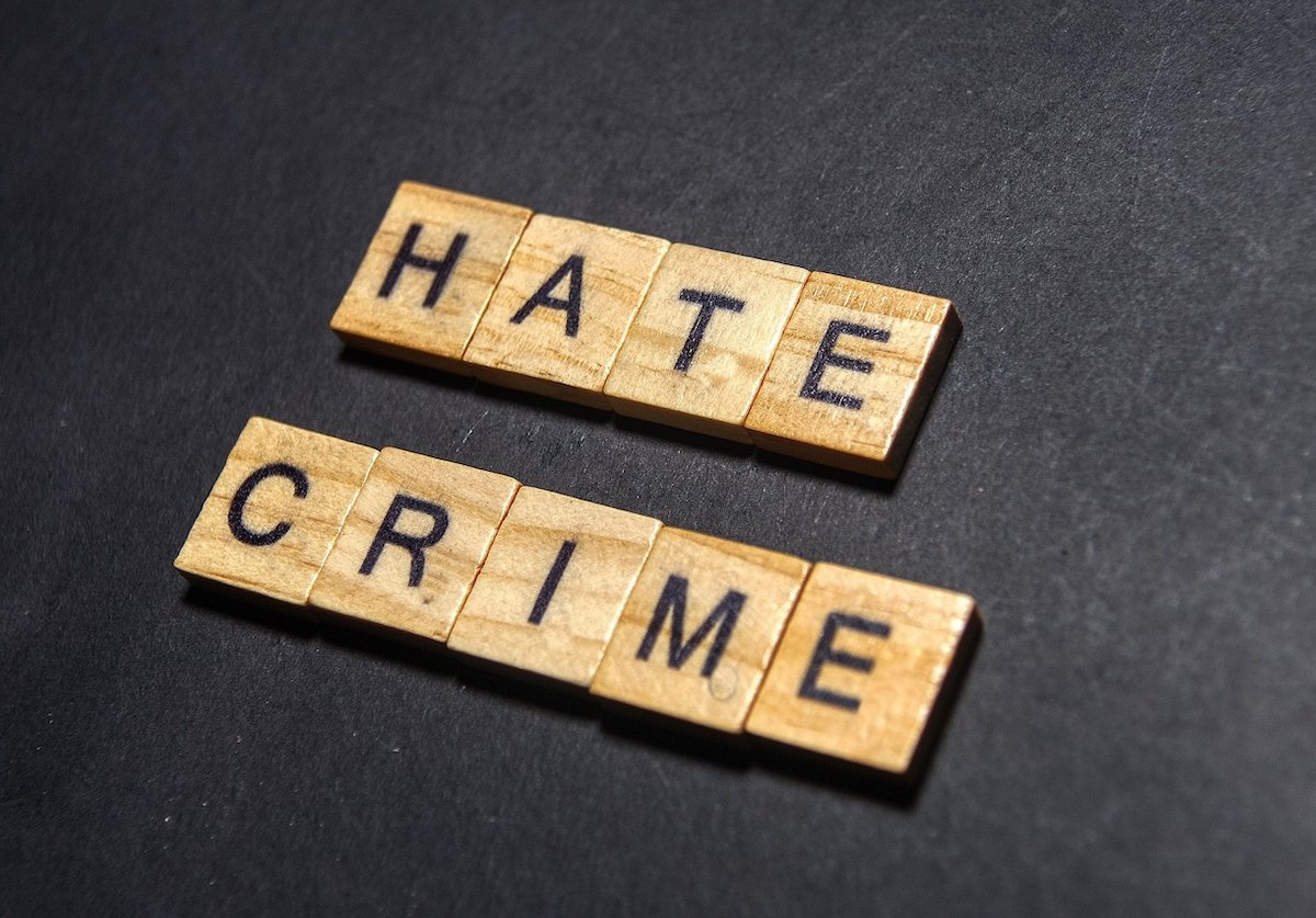 "Hate Crime" spelled out in Scrabble tiles against a black table