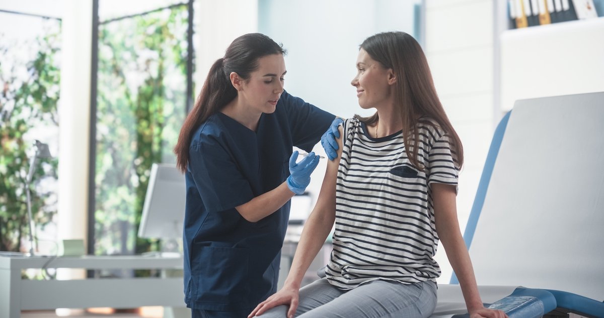 Provider injecting a young woman with a depo provera shot in a doctor's office