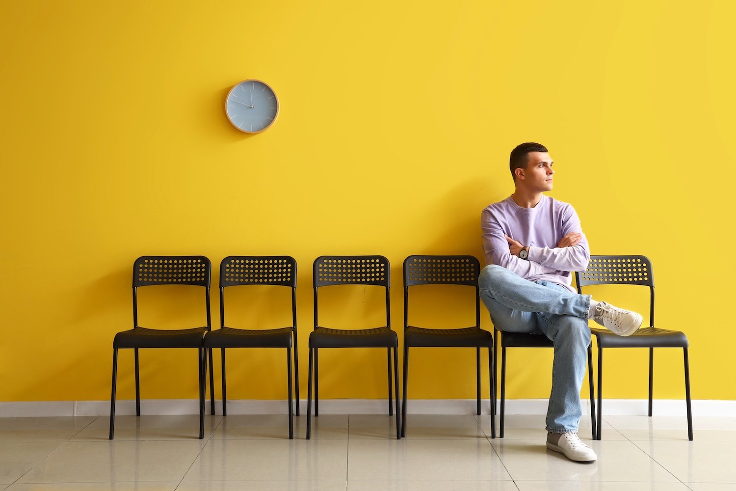 Solicitante de empleo esperando en una oficina con pared amarilla
