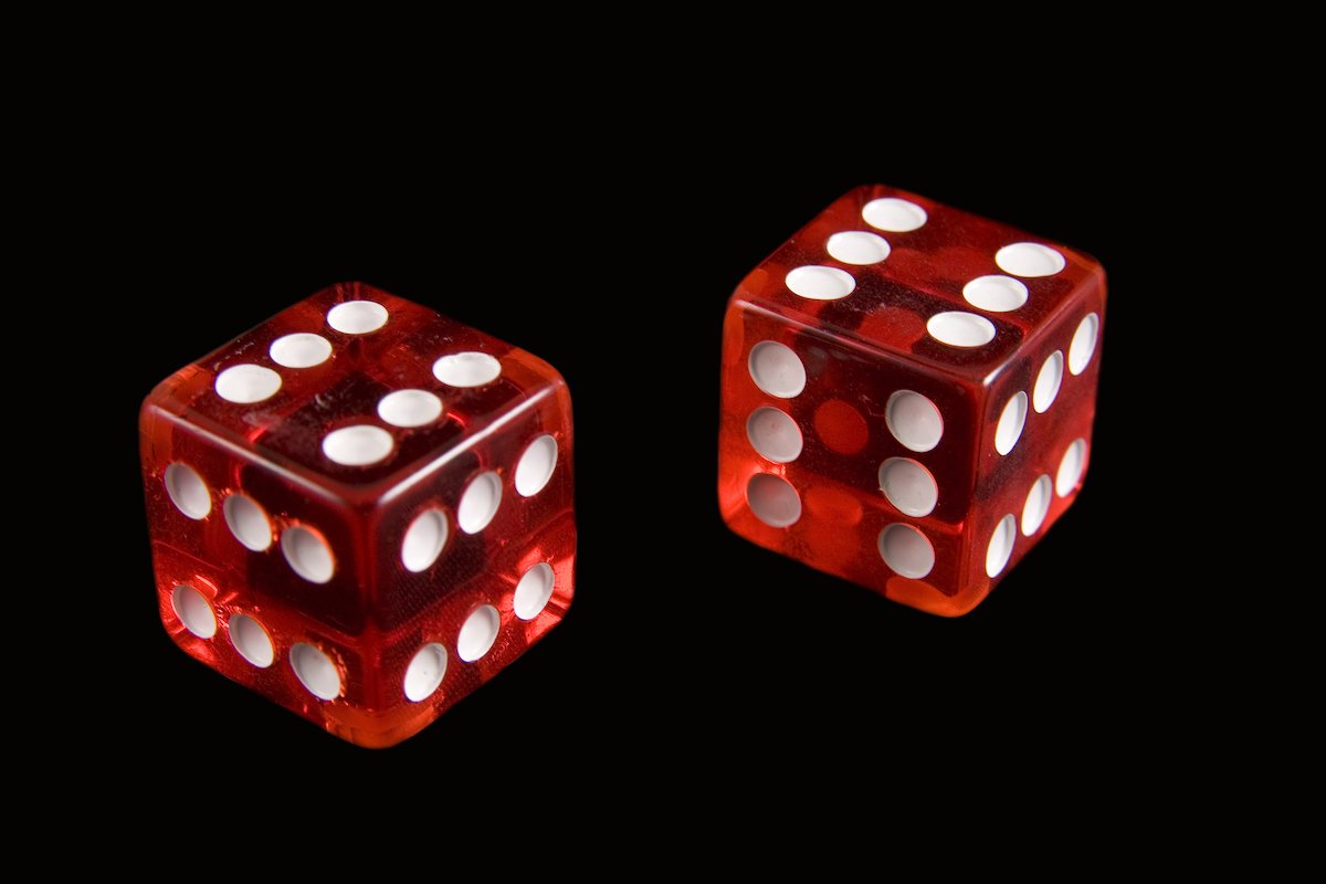 Fake dice with six dots on all sides against a black background