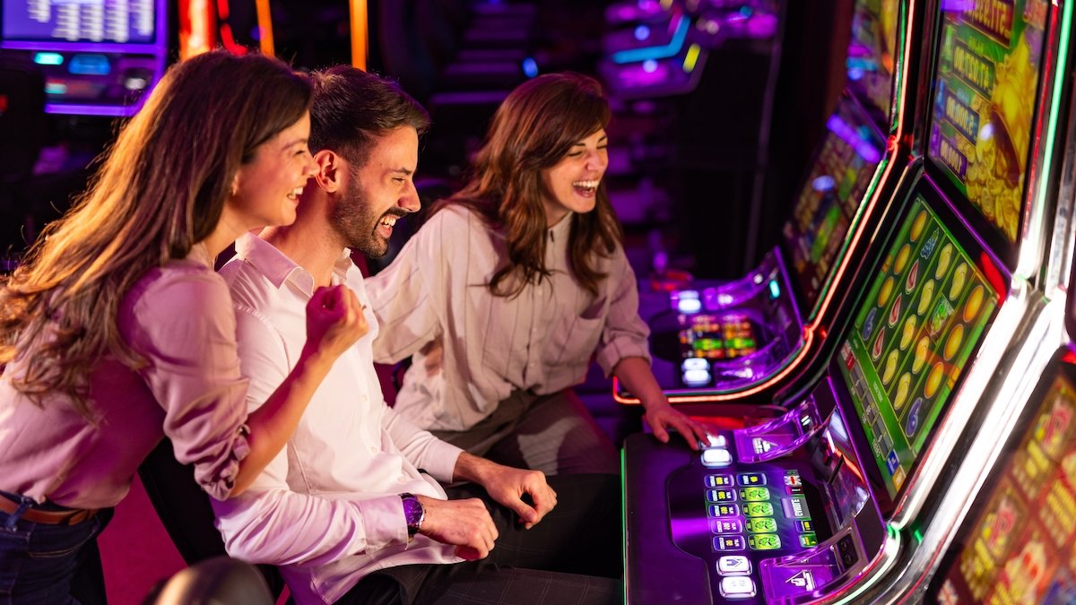 Three people gambling at slot machines in Las Vegas