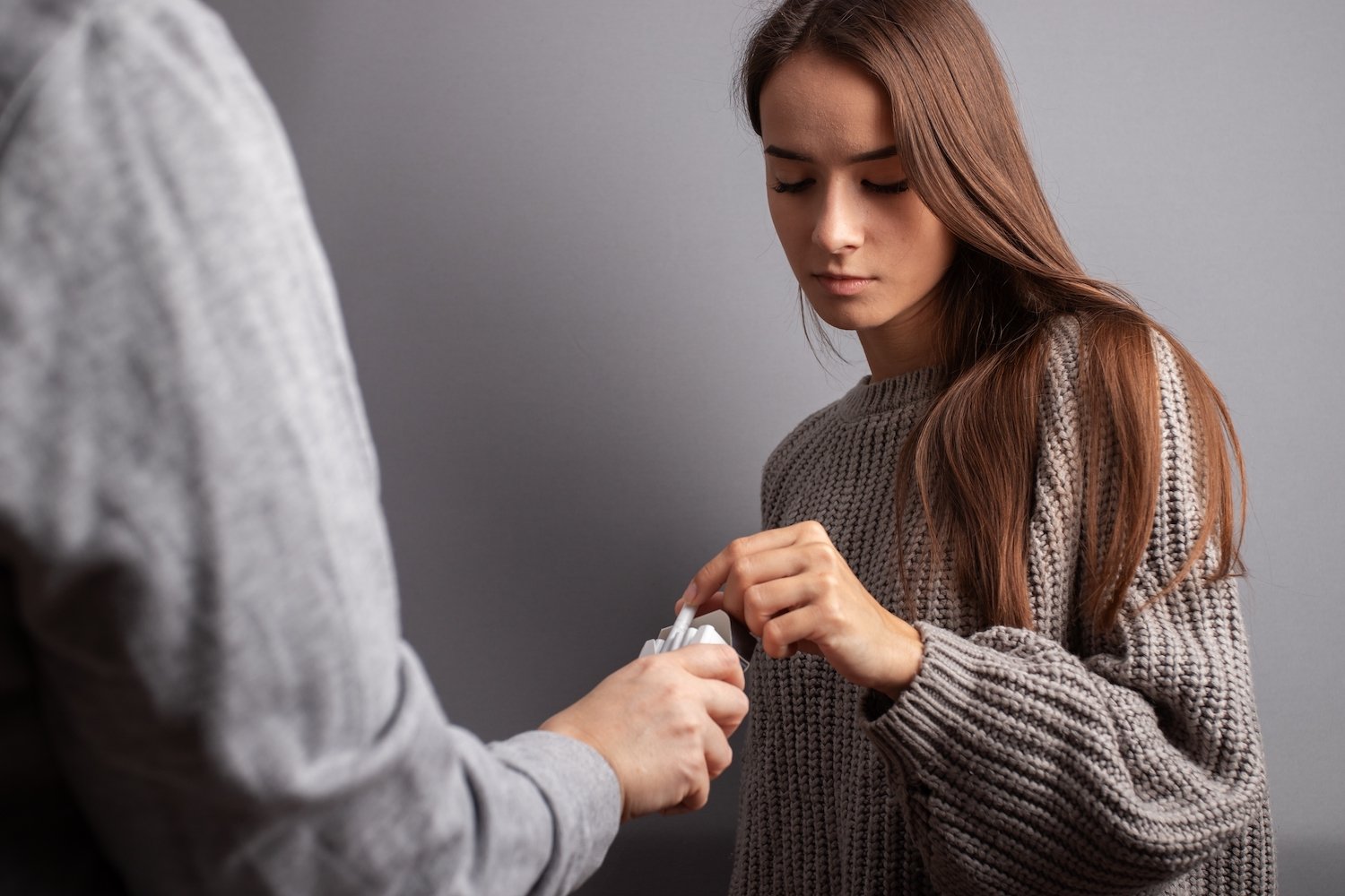 Young teen taking cigarettes from a stranger with bad intentions