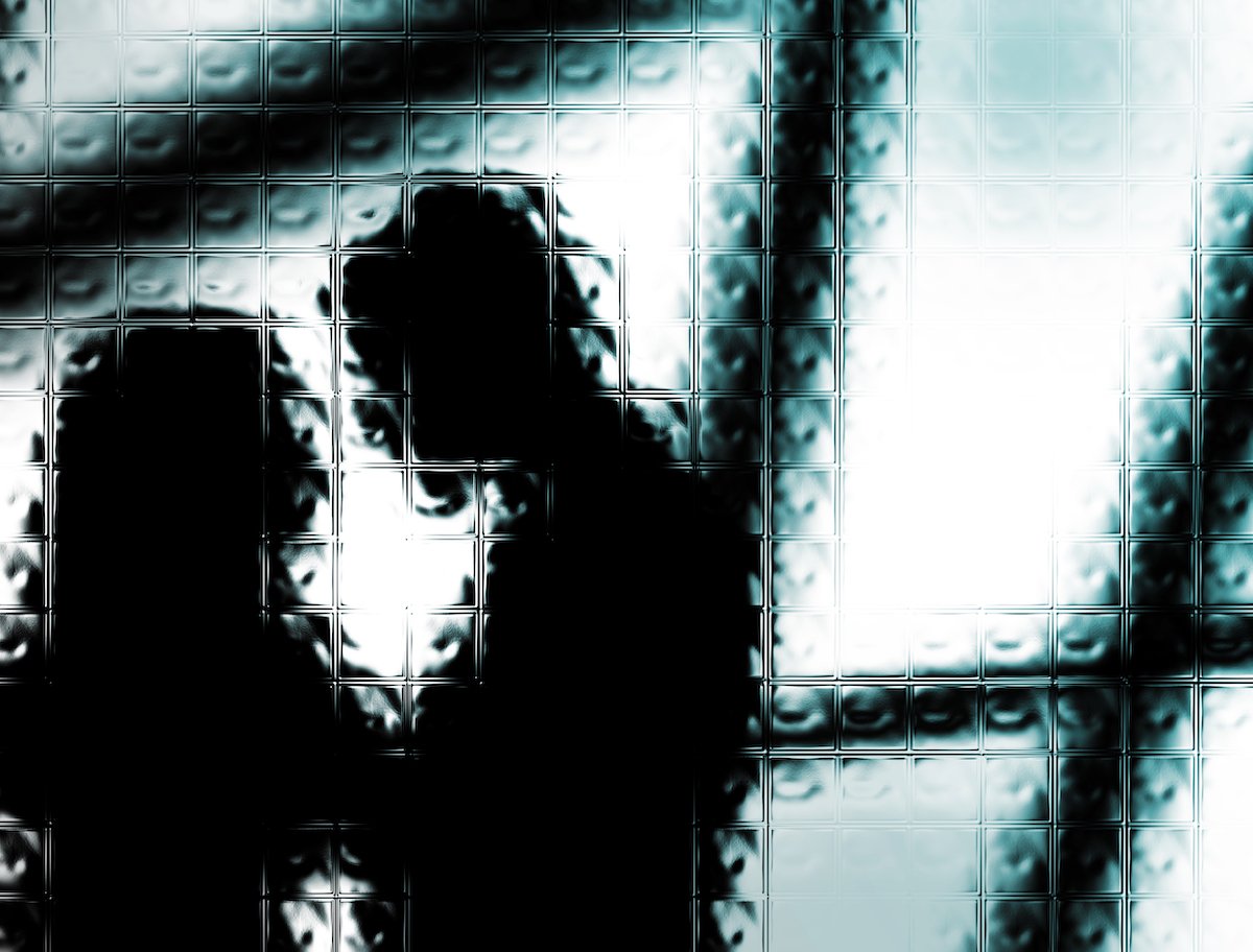 Silhouette of older man and younger relative behind glass