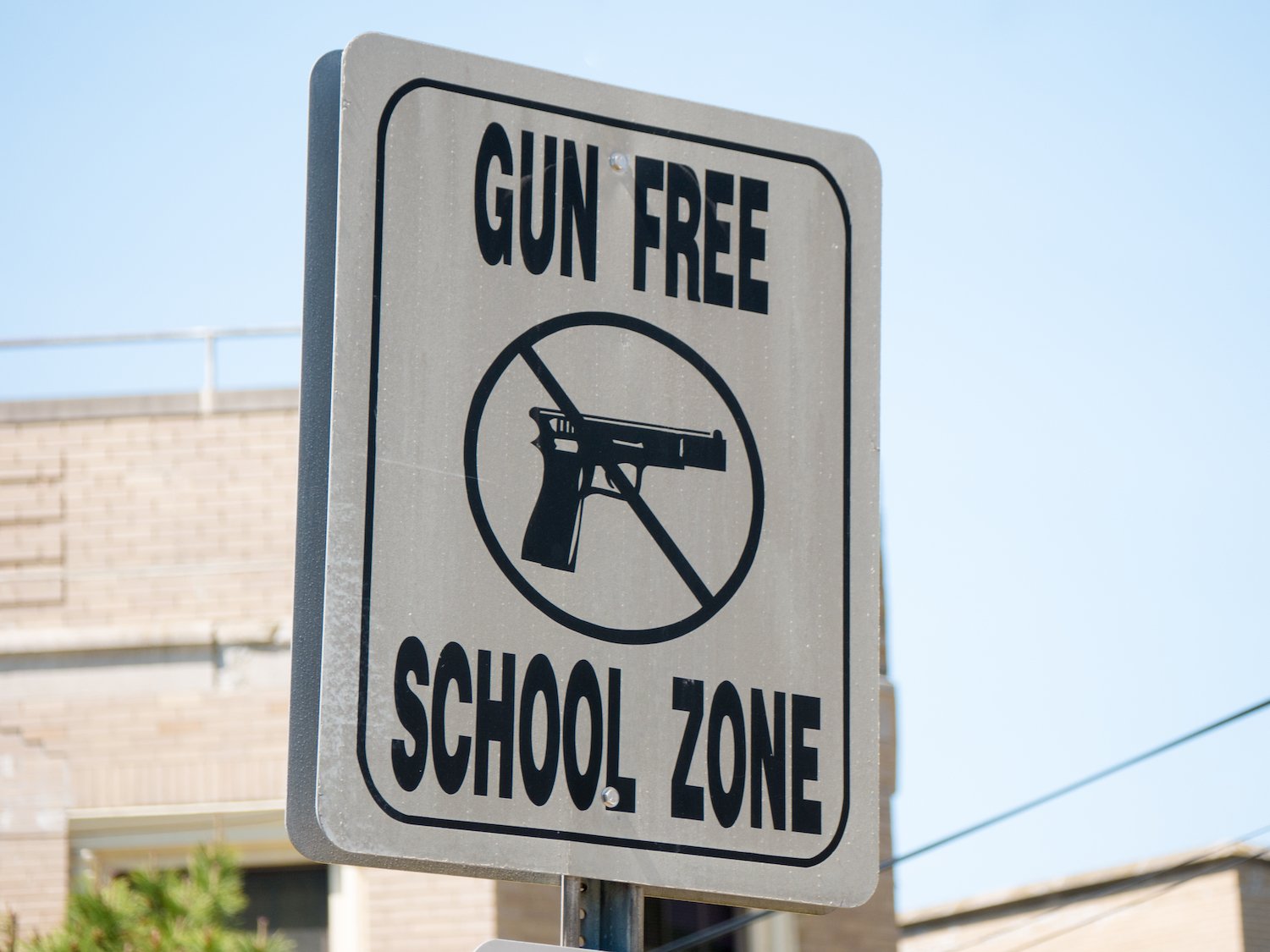 Outdoor sign that says "Gun Free School Zone"