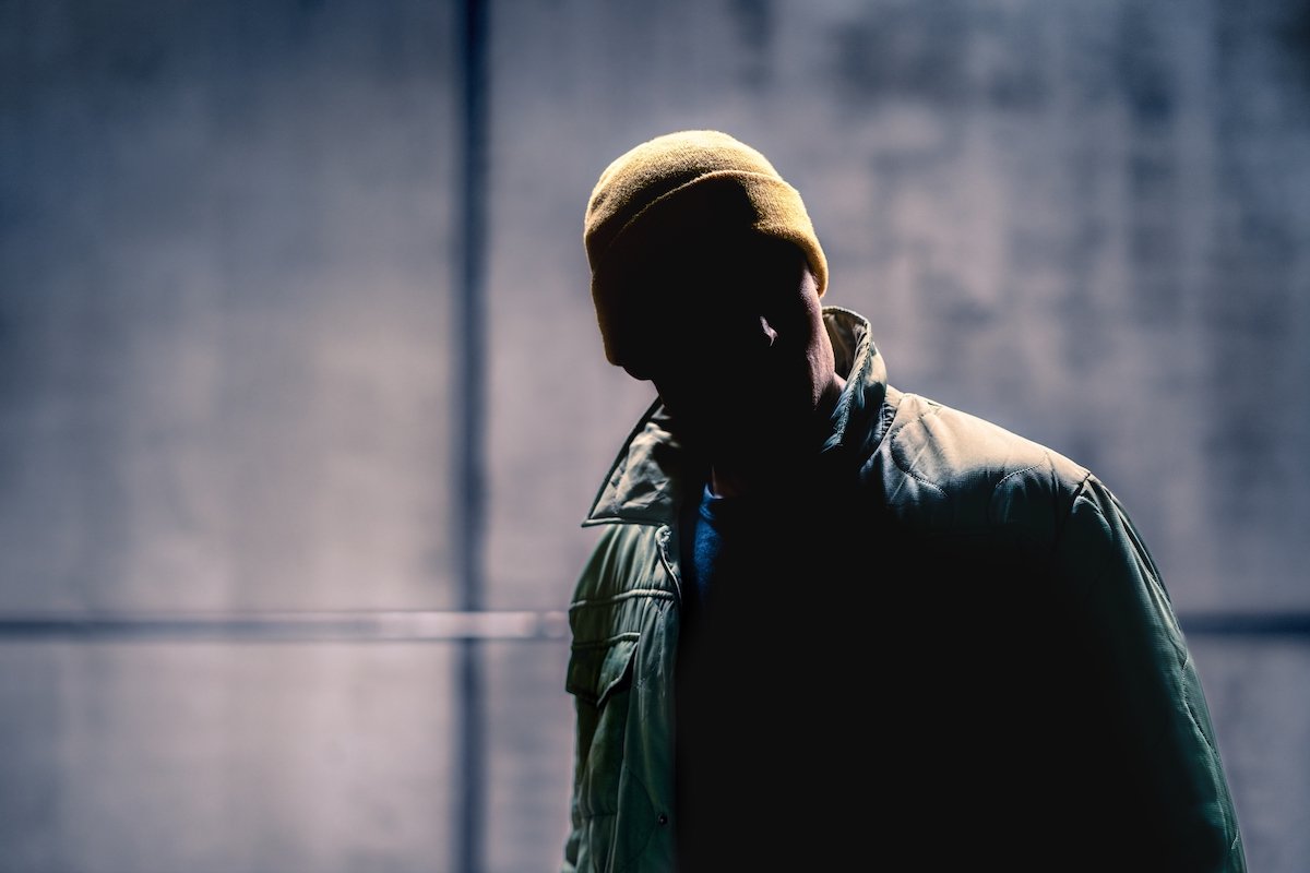 Suspicious stranger in a wool cap in a dark alley