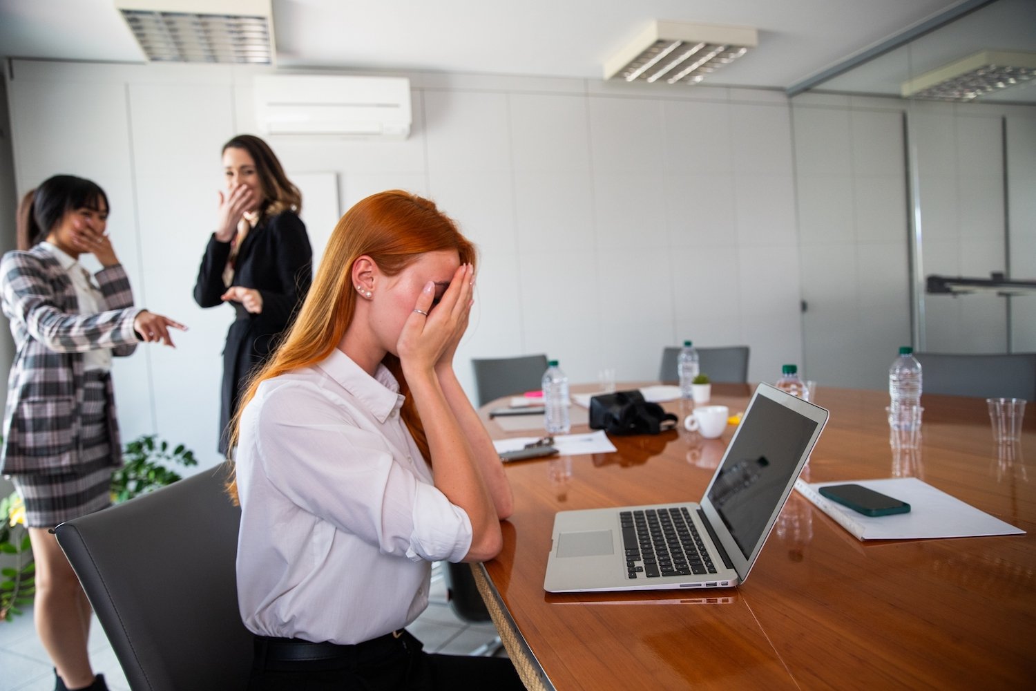 Woman being bullied at work by two co-workers