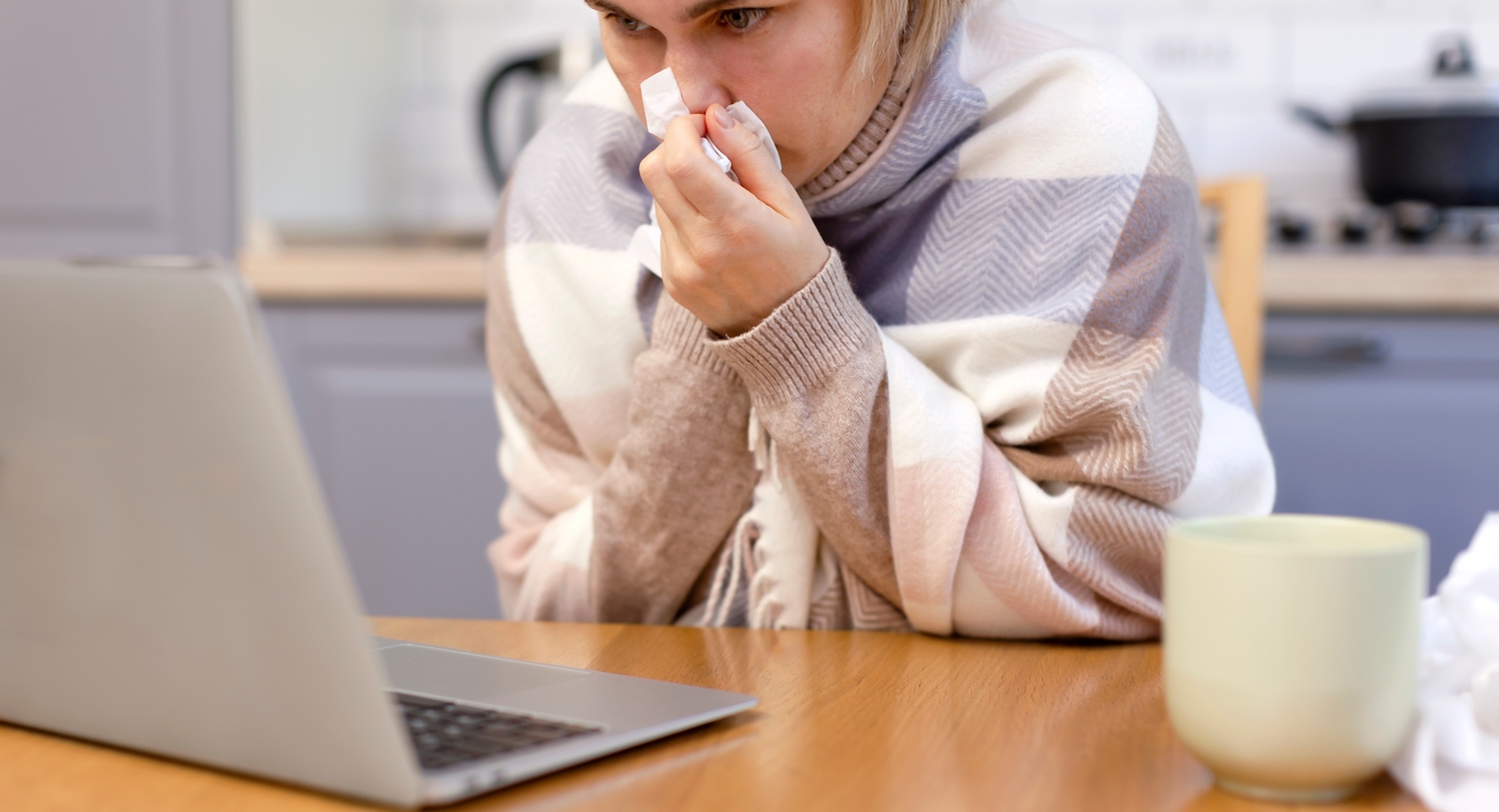 Sick employee working from home in front of her laptop