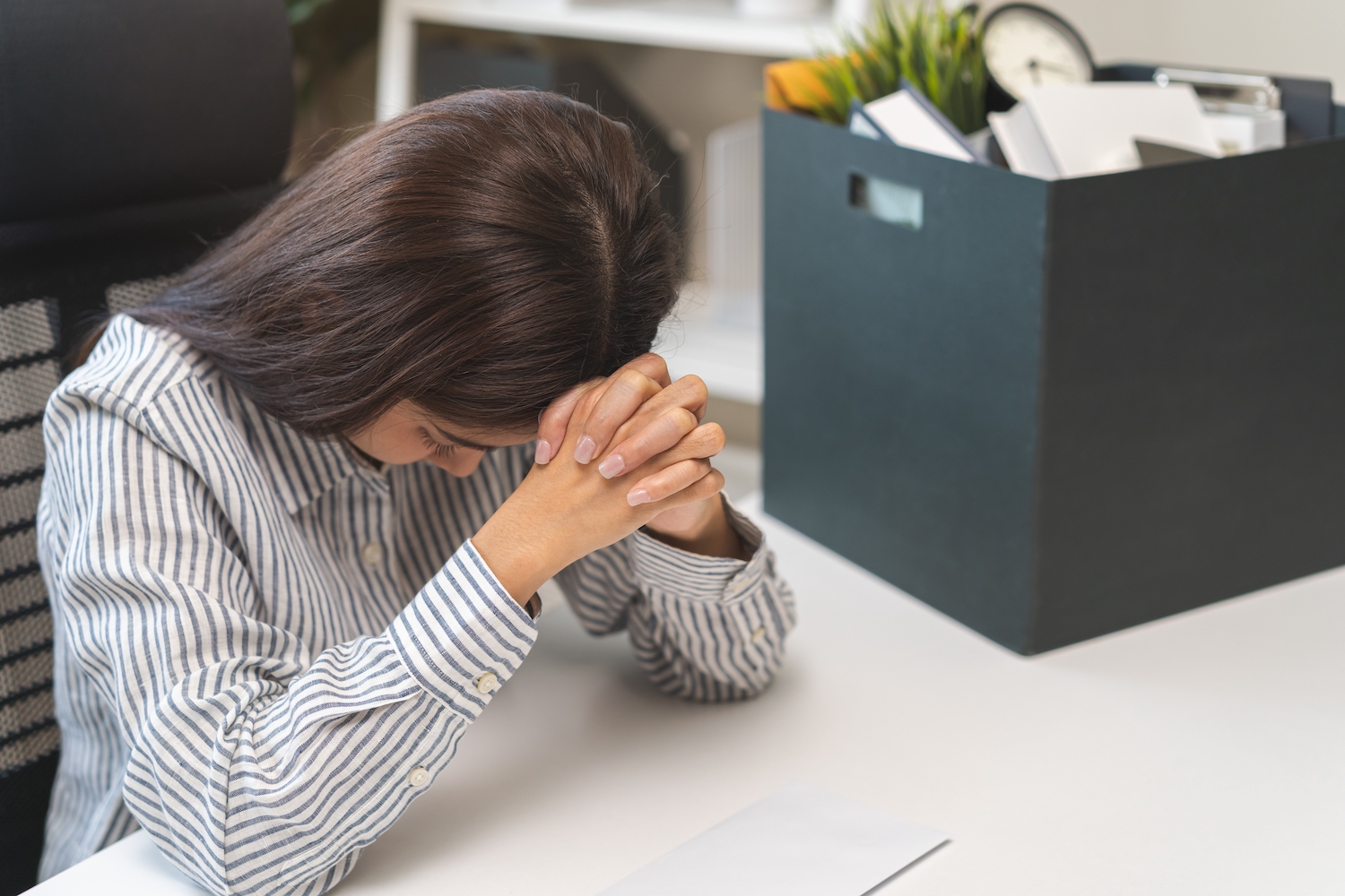 Empleado triste sosteniendo su cabeza con las manos en su escritorio de trabajo