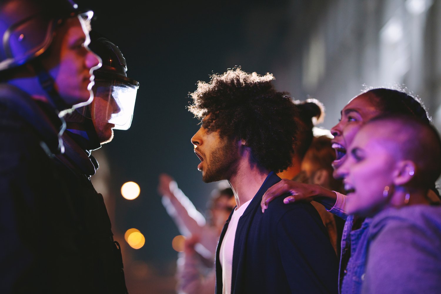 Hombre gritando a un oficial de policía durante una protesta
