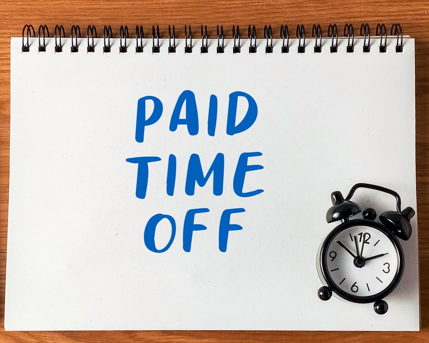 Cartel que dice "tiempo libre pagado" junto a un reloj despertador