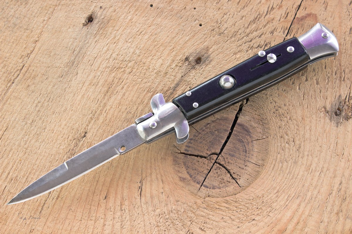 cuchillo automático desplegado sobre mesa de madera