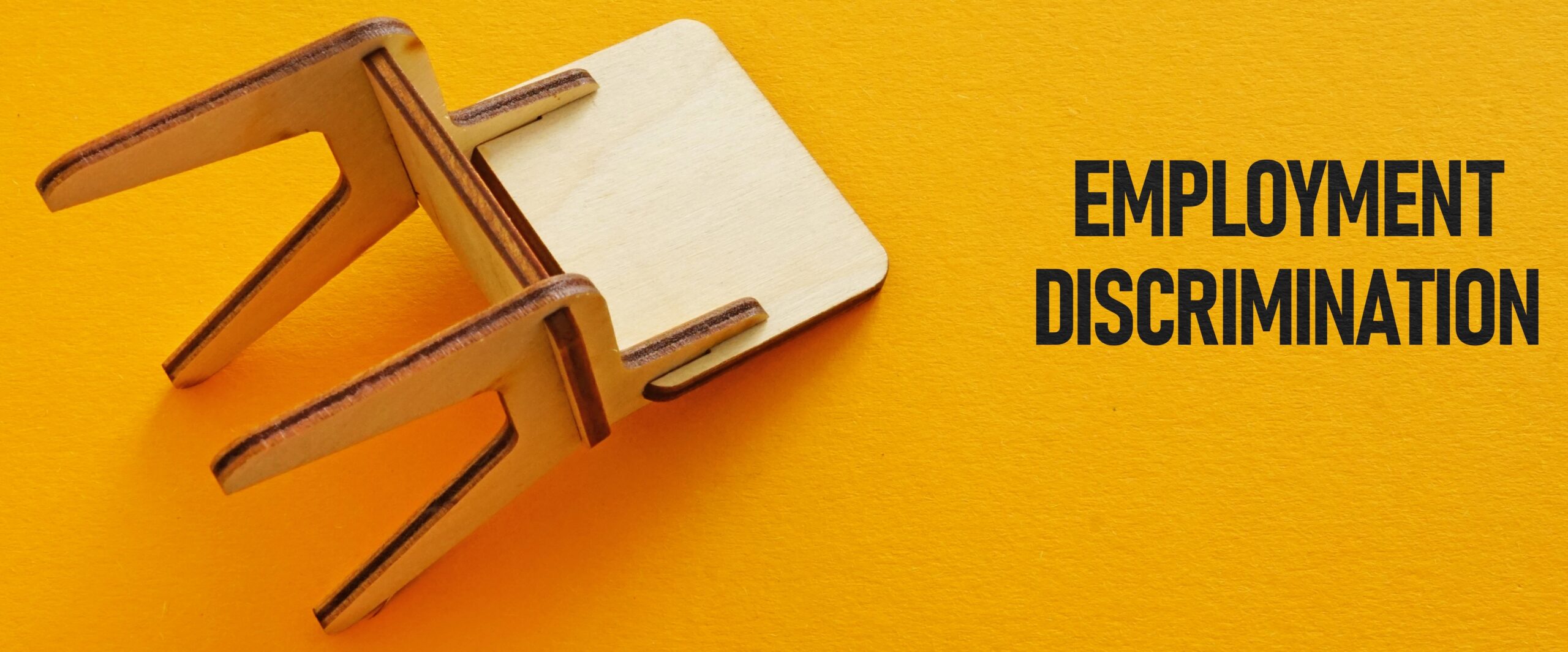 Cartel que dice "discriminación laboral" junto a una silla derribada