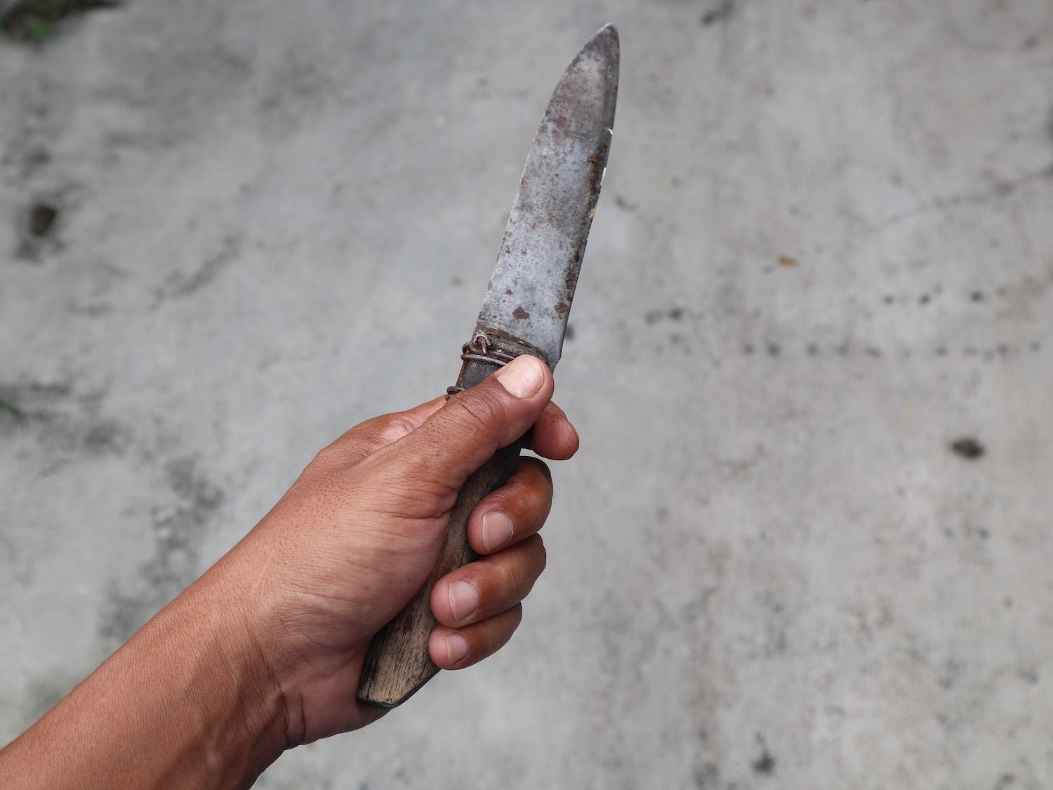 Closeup of hand brandishing a small knife in public in violation of PC 417