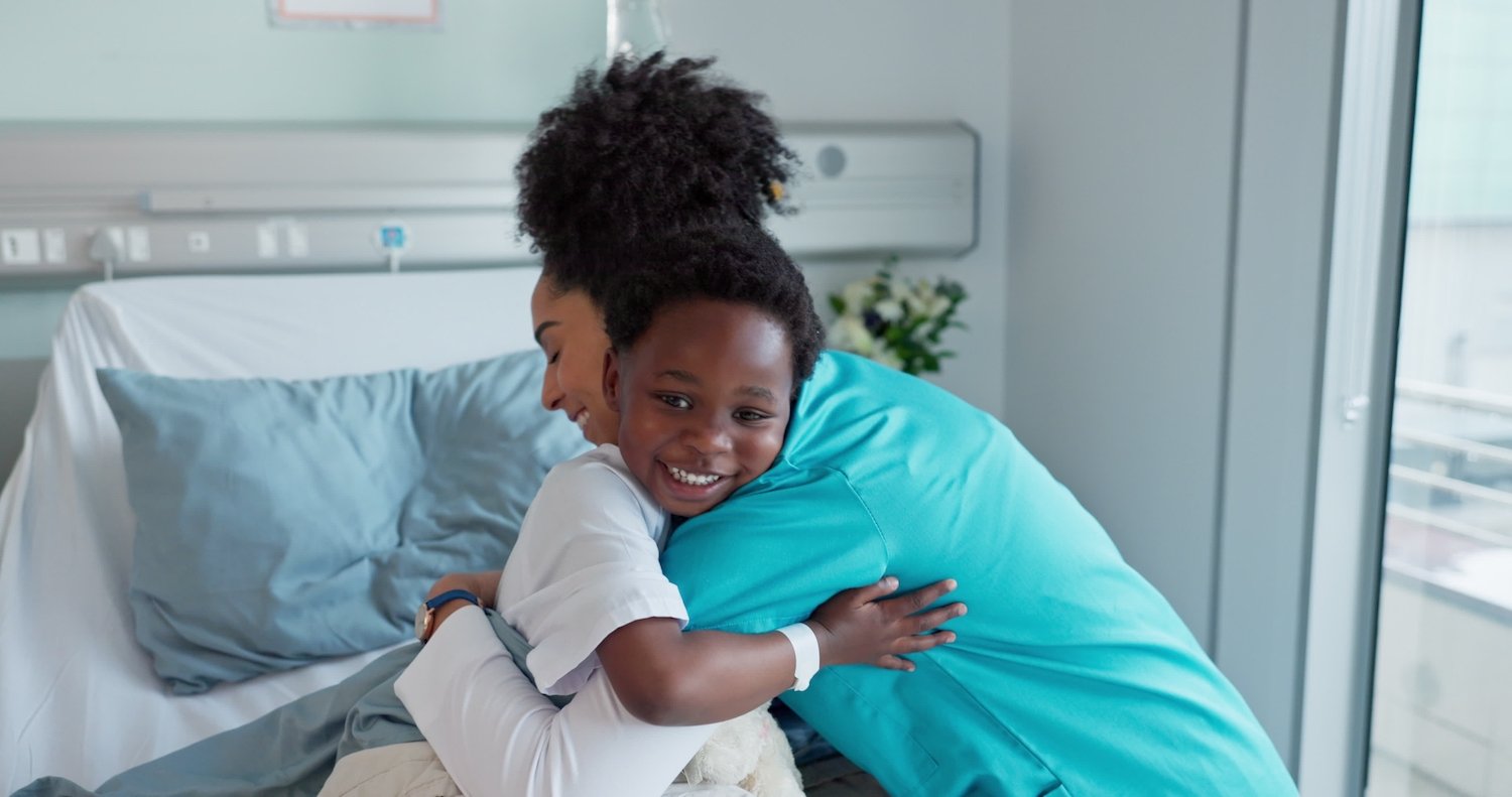 Enfermera abrazando a un niño en un hospital